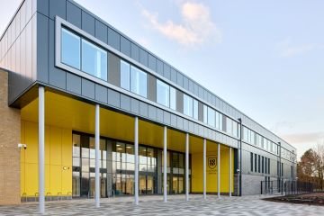 A modern school building with a yellow entrance